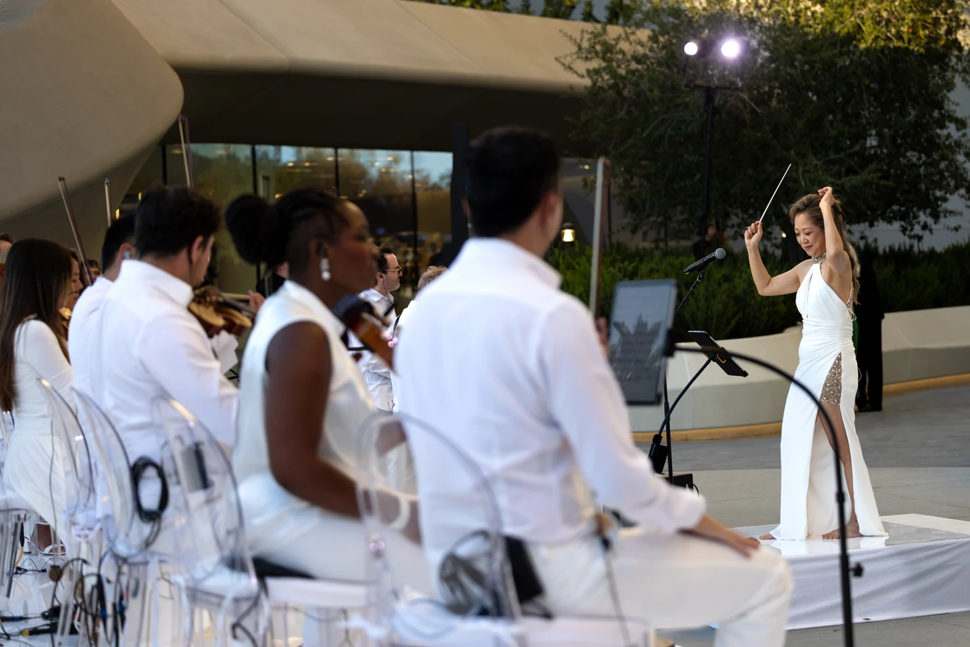 Musicians listening closely during an outdoor orchestral performance